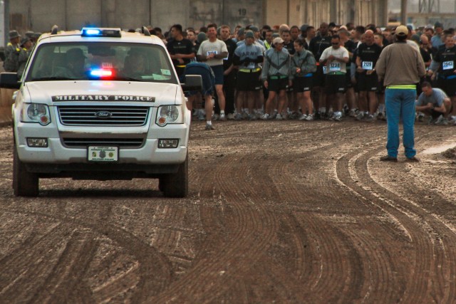 CAMP TAJI, Iraq - Participants taking part in the Fallen Soldier Half-Marathon memorial run gather at the start line Feb. 28. The run was held in honor of all service members who have given their lives during Operation Iraqi Freedom. Heavy rain...