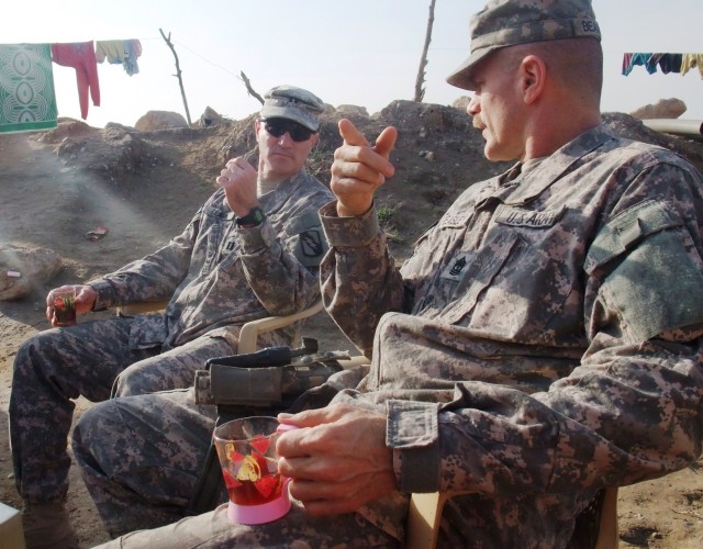 CONTINGENCY OPERATING LOCATION Q-WEST, Iraq -Capt. Drew Clark, a company commander from Madison, Miss., and 1st Sgt. John L. Beasely, a company senior noncommissioned officer from Hernando, Miss., chat while drinking chai tea at the home of a farmer ...