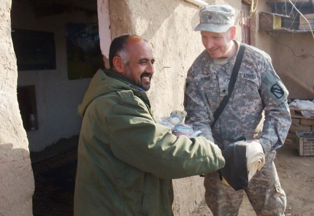CONTINGENCY OPERATING LOCATION Q-WEST, Iraq -Khalil Abrahim (left), a farmer who grows wheat and raises sheep near Al Qayarrah, shakes hands with Spc. Daniel Burke, a gun truck driver from Apalachicola, Fla., when Burke and other members of his unit ...