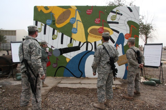Soldiers from the 1483rd Transportation Company, 541st Combat Sustainment Support Battalion, 15th Sustainment Brigade, 13th Sustainment Command (Expeditionary), admire the mural painted on the side of a building outside of the company MWR.  The...