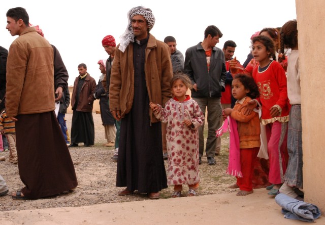 CONTINGENCY OPERATING LOCATION Q-WEST, Iraq - Townsfolk crowd into the schoolyard of Jedallah Anuk, a small village near Q-West, to receive gifts sent by the people of Barrington, R.I., and delivered by Mississippi Guardsmen, Feb. 1. Members of A...