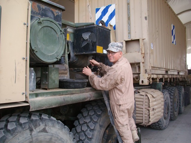 CAMP LIBERTY, Iraq- Pfc. Jason Watts of Fort Bragg, N.C., and a generator mechanic assigned to the 659th Maintenance Company's palletized load system maintenance support team, works on a PLS to repair it to fully mission capable standards.   His team...