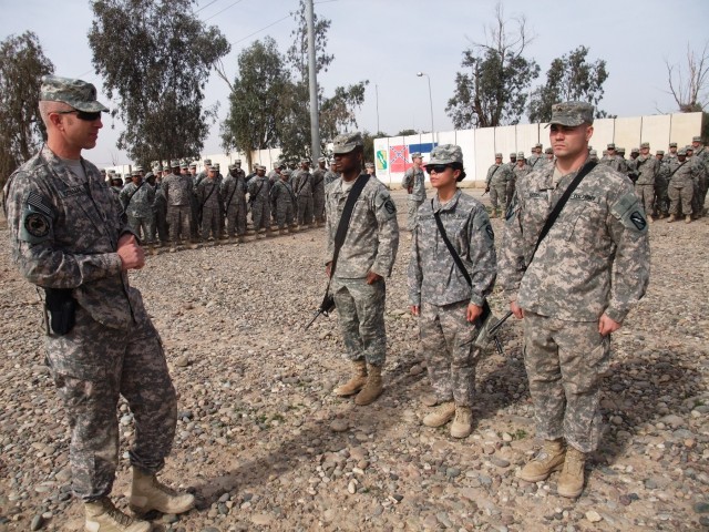 CONTINGENCY OPERATING LOCATION Q-WEST, Iraq - Lt. Col. Kerry Goodman (left), resident of Meridian, Miss., and commander of 2nd Battalion, 198th Combined Arms, 155th Brigade Combat Team out of Senatobia, Miss., awards deployment coins to Spc....