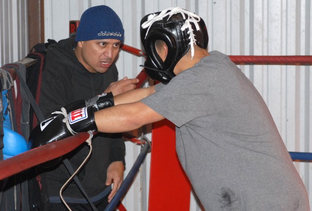KILLEEN, Texas-Sgt. 1st Class Armando Rivera (left), Brownsville, Texas native, talks to a young boxer at the Miracle Boxing Club in Killeen, Texas, Feb. 18. Rivera has been teaching young boxers for the last nine years, both in the U.S. and while...