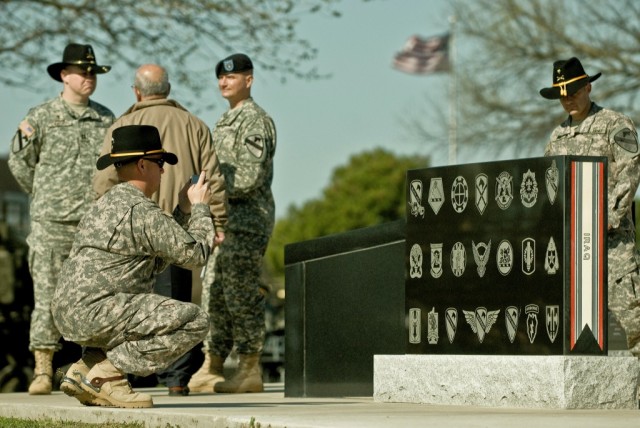FORT HOOD, Texas-Soldiers from the 1st Cavalry Division gaze upon the newest Operation Iraqi Freedom 08-10 campaign stone added to the Division's Memorial, here, at Fort Hood March 12. The stone has each brigade's patch that supported the division du...
