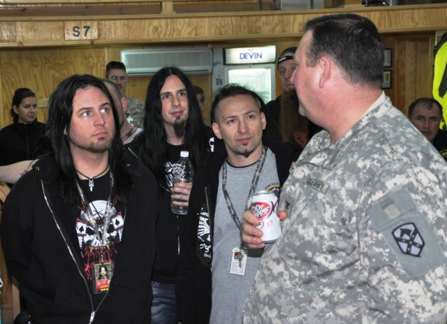 Col. Larry Phelps, the commander of the 15th Sustainment Brigade, explains the brigade's mission to members of the heavy metal band Five Finger Death Punch during a tour of Contingency Operating Location Q-West, Iraq, March 5. (U.S. Army photo by...