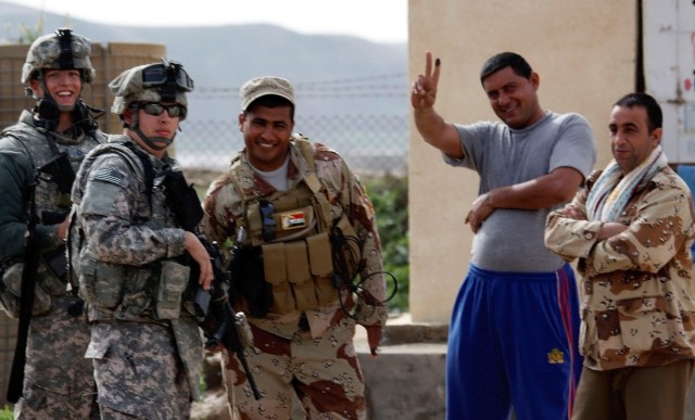 CONTINGENCY OPERATING LOCATION Q-WEST, Iraq -Iraqi Army Soldiers of 1st Company, 2nd Battalion, 26th Brigade, who just voted in Ninawa Province during the special elections talk with Soldiers of C Company, 1st Squadron, 278th Armored Cavalry Regiment...