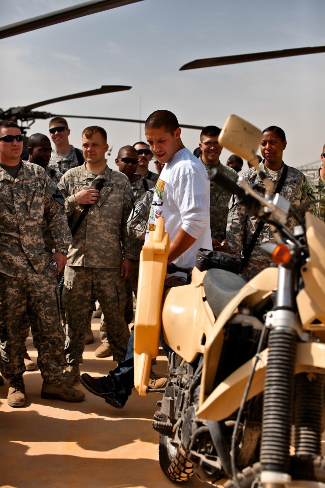 CAMP TAJI, Iraq - During a visit with Soldiers from 1st Air Cavalry Brigade, 1st Cavalry Division, U.S. Division-Center, actor Theo Rossi (white shirt), a lead actor in the hit TV show "Sons of Anarchy," looks at an Iraqi Army motorcycle March 15....