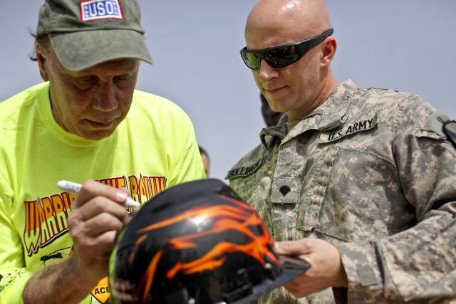 CAMP TAJI, Iraq - Spc. Chris Bollingmo, from New Ulm, Minn., an AH-64D Apache attack helicopter crew chief in Company B, 615th Aviation Support Battalion, 1st Air Cavalry Brigade, 1st Cavalry Division, U.S. Division-Center, gets his helmet signed...