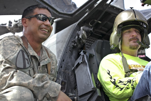 CAMP TAJI, Iraq - While sitting in an AH-64D Apache attack helicopter March 15, Kim Coates talks with Chief Warrant Officer 3 Rolando Sanchez, an Apache maintenance test pilot in Company C, 1st Battalion, 227th Aviation Regiment, 1st Air Cavalry...