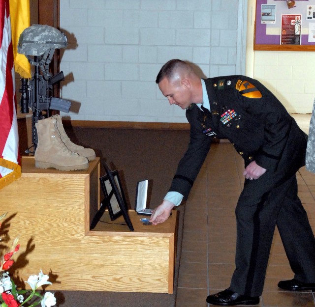 FORT HOOD, Texas-Lt. Col. John Cushing, commander of the 1st Squadron, 9th Cavalry Regiment, 4th Brigade Combat Team, 1st Cavalry Division, places a battalion coin of achievement on 1st Lt. Michael Thomas Jue's memorial during the remembrance...