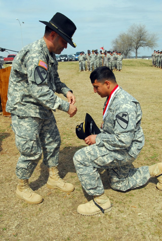 FORT HOOD, Texas-Capt. Nathan Jennings, C Troop, 4th Squadron, 9th Cavalry Regiment, 2nd Brigade Combat Team, 1st Cavalry Division, kneels before Col. Ryan Gonsalves, the commander of 2nd BCT, as he inducts him into the Order of St. George with...