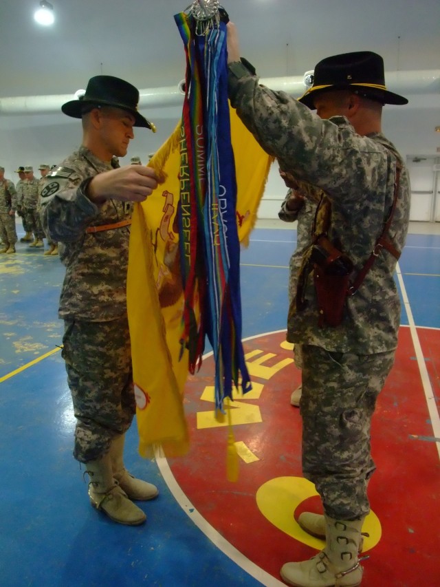 CONTINGENCY OPERATING LOCATION Q-WEST, Iraq - Command Sgt. Maj. Michael L. Butler and Lt. Col. Jimmie L. Cole, Jr., commander of 1st Squadron, 278th Armored Cavalry Regiment, uncase their unit's colors during a Transfer Of Authority ceremony...