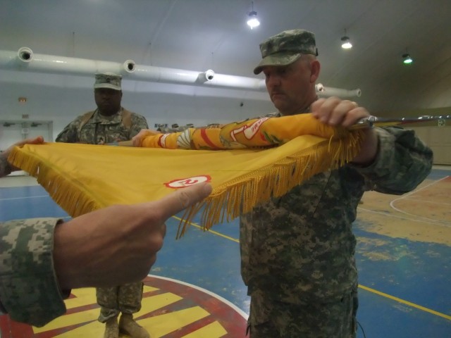 CONTINGENCY OPERATING LOCATION Q-WEST, Iraq -With the help of his commander, Lt. Col. Kerry W. Goodman, Command Sgt. Maj. Perry Campbell cases the 2nd Battalion, 198th Combined Arms colors during a Transfer Of Authority ceremony between 1st...