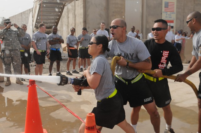 Members of team "Wolf Pack," with the 63rd Ordnance Company, 80th Ordnance Battalion, 15th Sustainment Brigade, 13th Sustainment Command (Expeditionary) fire a hose at a target during the hose-roll event at the fire muster March 13 at Joint Base...
