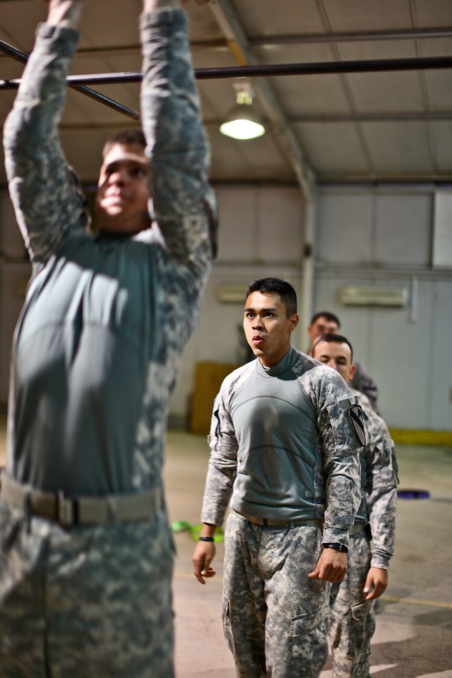CAMP TAJI, Iraq - Sgt. Luis Garcia (background), from Bryant, Texas, a squad leader in Company F, 3rd Battalion, 227th Aviation Regiment, 1st Air Cavalry Brigade, 1st Cavalry Division, U.S. Division-Center, prepares himself before replacing his teamm...