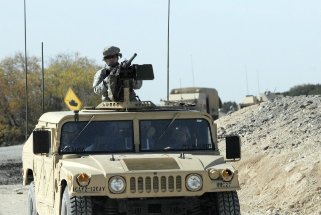 FORT HOOD, Texas-Soldiers assigned to the 2nd Battalion, 12th Cavalry Regiment, 4th Brigade Combat Team, 1st Cavalry Division ride down range to move, shoot and communicate as a crew during humvee training at the Blackwell Multi-Use Range, March 23. ...