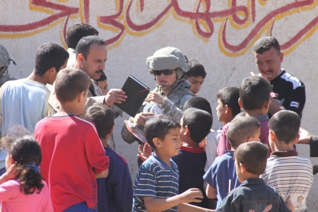Spc. Zandrast R. Rast, a supply clerk with the 3666th Support Maintenance Company, 541st Combat Sustainment Support Battalion, 15th Sustainment Brigade, 13th Sustainment Command (Expeditionary), talks to locals during a humanitarian aid mission...