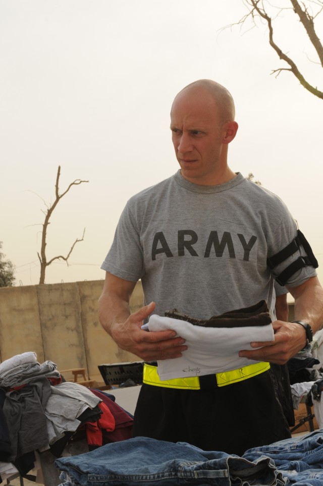 Staff Sgt. Brent J. Allred, a supply sergeant with the 3666th Support Maintenance Company, 541st Combat Sustainment Support Battalion, 15th Sustainment Brigade, 13th Sustainment Command (Expeditionary), folds clothes to be given to local Iraqi...