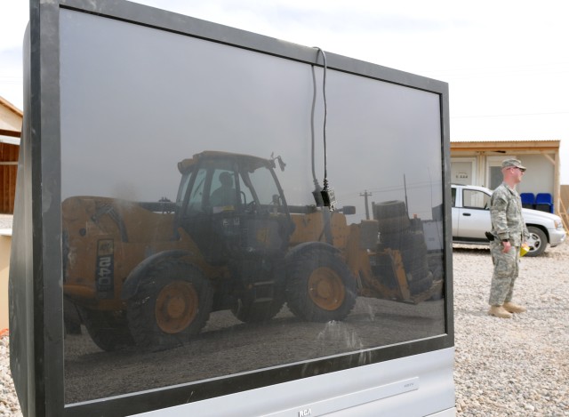 A forklift removing excess equipment from a truck at the Operation Clean Sweep yard is reflected in a turned-in TV here March 23. Operation Clean sweep is part of the 15th Sustainment Brigade, 13th Sustainment Command (Expeditionary)'s, ongoing effor...