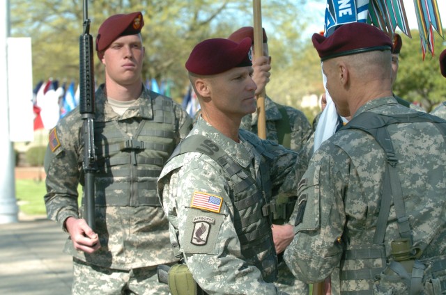 In-coming Command Sgt. Maj. Earl L. Rice receives the Corps colors from Lt. Gen. Frank Helmick