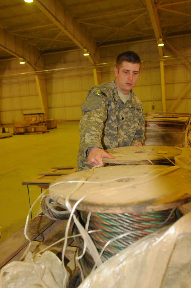 Spc. Todd Boban, a Supply Support Activity storage clerk with the 716th Quartermaster Company, 80th Ordnance Battalion, 15th Sustainment Brigade, 13th Sustainment Command (Expeditionary) and a Pittsburgh native, moves cargo off a pallet at the SSA Ma...