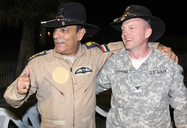 CAMP TAJI, Iraq - Col. Douglas Gabram (right) of Cleveland, Ohio, commander, 1st Air Cavalry Brigade, 1st Cavalry Division, laughs as Iraqi Air Force Brig. Gen. Nazim Liftah al-Agwadi, commander, al-Taji Air Field, seeks approval from his troops for ...