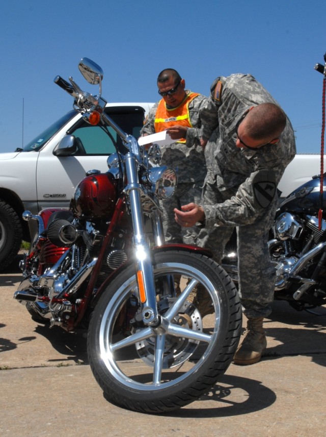 FORT HOOD, Texas-Cpt. Eric Dunkley (right), a Spokane, Wash. native with 4th Squadron, 9th Cavalry Regiment, 2nd Brigade Combat Team, 1st Cavalry Division, inspects his motorcycle's headlights with the help of Sgt. 1st Class Baldomero Moreno, from...