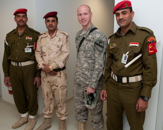 CAMP MEJID, Iraq - Spc. Christopher Howard, an Apache aircraft maintainer with 4-227th Attack Reconnaissance Battalion, 1st Air Cavalry Brigade, 1st Cavalry Division, stands with Iraqi soldiers inside the headquarters of the 7th Iraqi Army...