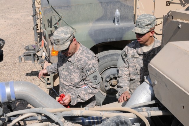 Sgt. Gregory T. Garrett and Pvt. Jacob F. Ray, both mechanics with the 2101st Transportation Company out of Demopolis, Ala., 541st Combat Sustainment Support Battalion, 15th Sustainment Brigade, 13th Sustainment Command (Expeditionary), check the oil...