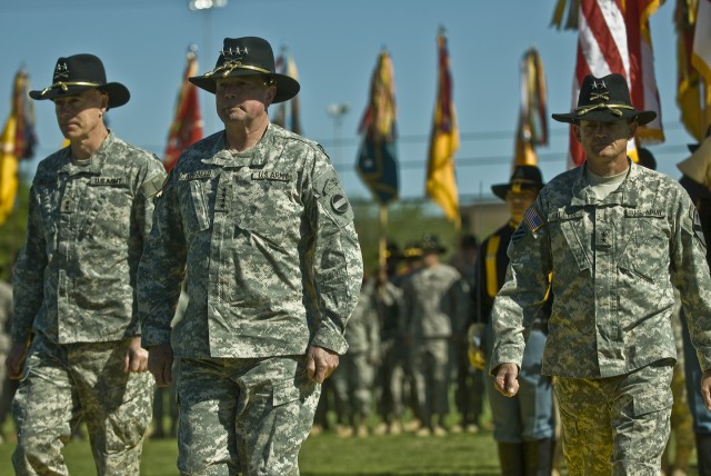 FORT HOOD, Texas-Reviewing officer for the 1st Cavalry Division's Change of Command Ceremony, Gen. Charles Campbell (foreground), escorts outgoing 1st Vav. Div. Commander Maj. Gen. Daniel Bolger (left), and 1st Cavalry Division's newest commander,...