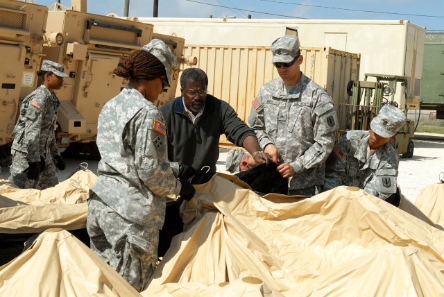 FORT HOOD, Texas-Eric Johnson (center), a trainer for Northrop Grumman, teaches Soldiers how to use the new deployable rapid assembly shelter (DRASH) system the Army is streamlining. Johnson has been training Soldiers on this system for two and a...