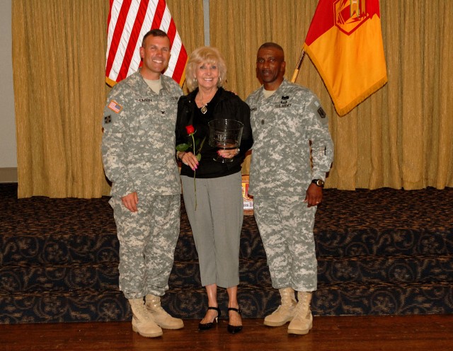 FORT HOOD, Texas-Mrs. Jeanne Isdale (center), a volunteer, receives a gift from Col. John Thomson (left), commander of the 41st Fires Brigade, and Command Sgt. Maj. Kelvin Hughes at the annual Volunteer Recognition Ceremony, April 15, at Club...