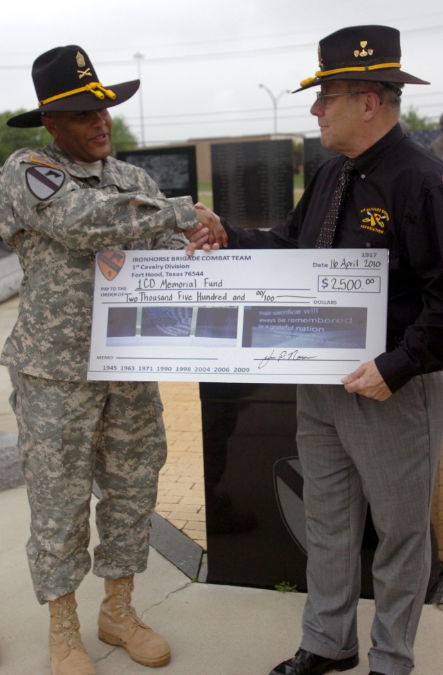 FORT HOOD, Texas - Command Sgt. Maj. (Ret.) Dennis Webster (right), the executive director of the 1st Cavalry Division Association, receives a $2,500 check from Command Sgt. Maj. James Norman, 1st Brigade Combat Team, 1st Cav. Div., for the...