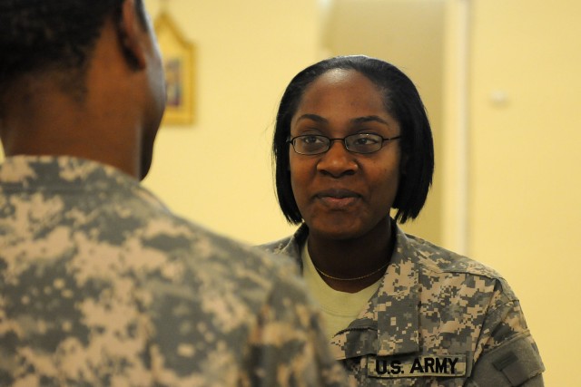 Spc. Elyse Jones, a logistics specialist with the Special Troops Battalion, 15th Sustainment Brigade, renews her vows to her husband during a ceremony April 13 at Contingency Operating Location Q-West, Iraq. (U.S. Army photo by Staff Sgt. Rob...