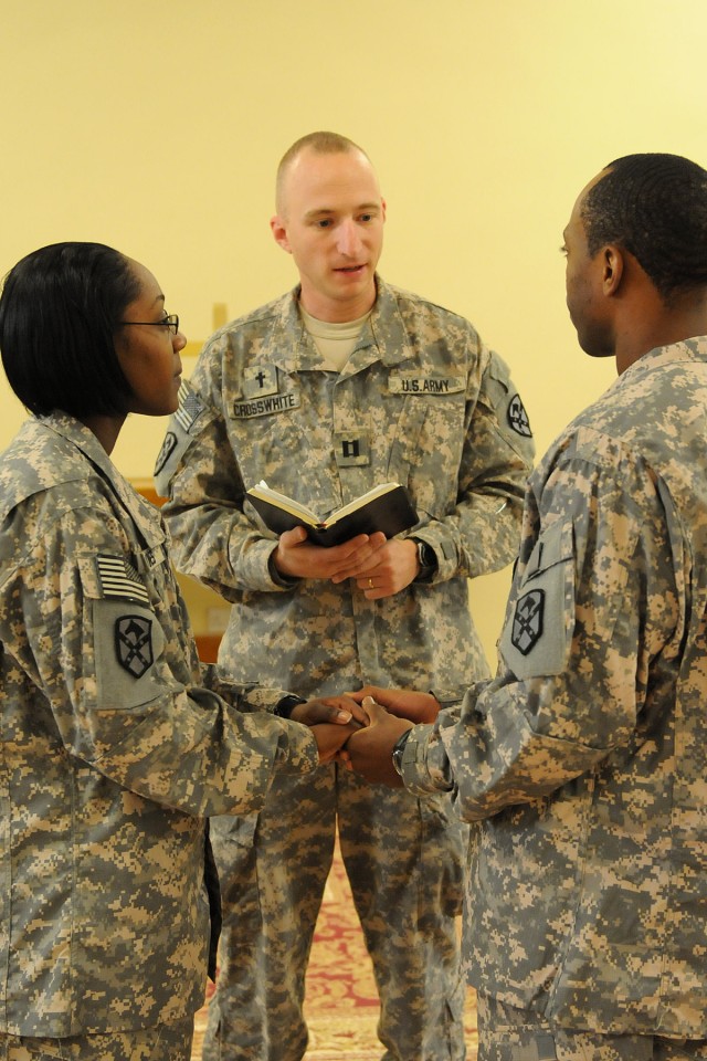 Sgt. Christopher Jones and Spc. Elyse Jones, a food service specialist and a logistics specialist both with the Headquarters and Headquarters Company, Special Troops Battalion, 15th Sustainment Brigade, renew their wedding vows in front of Capt....
