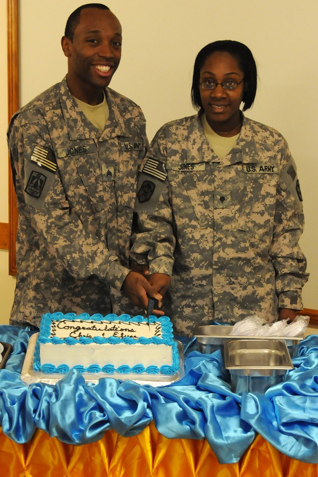 Sgt. Christopher Jones and Spc. Elyse Jones, a food service specialist and a logistics specialist both with the Headquarters and Headquarters Company, Special Troops Battalion, 15th Sustainment Brigade, cut their cake after renewing their wedding...