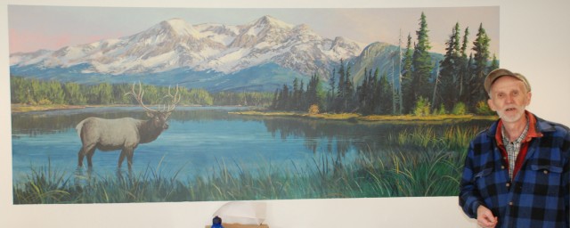 Lee Jensen poses with a mural he painted.