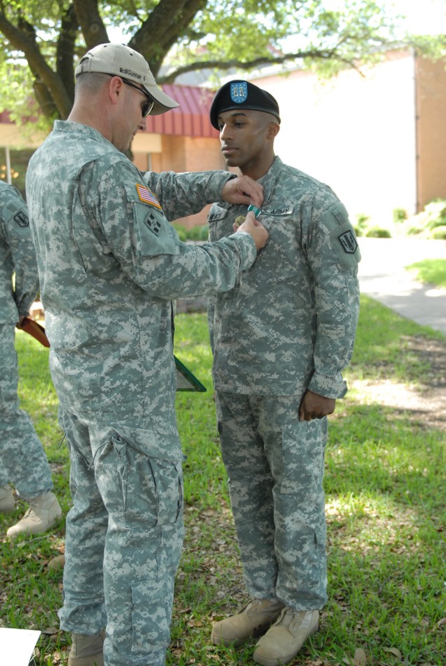FORT HOOD, Texas - Capt. Cory McKoy, an intelligence analysis officer from White Oak, N.C., receives a Army Commendation Medal from Col. John Thomson, brigade commander for the 41st Fires Bde., April 23, at Club Hood for receiving the highest...