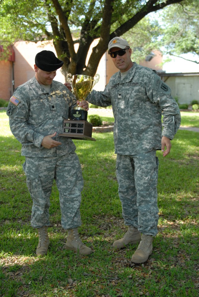 FORT HOOD, Texas - Lt. Col. James Davel (left), commander for 1st Battery, 21st Field Artillery Battalion  receives the gold cup trophy from Col. John Thomson, commander, 41st Fires Bde., April 23 at Club Hood, for his team having the highest...