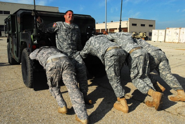 FORT HOOD, Texas-A team of five Soldiers from Headquarters and Headquarters Company, 2nd Special Troops Battalion, 2nd Brigade Combat Team, 1st Cavalry Division, struggle together as they push a humvee uphill during a strongman competition on Fort...