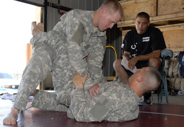 FORT HOOD, Texas-Spc. Travis Ritchie, from Scappoose, Ore., (top), demonstrates the proper escape and mount, trap and roll method on Pfc. Steve Gaetano, from Canton Ohio, as Sgt. 1st Class Juan Bruno, a skill level-4 combative instructor evaluates...