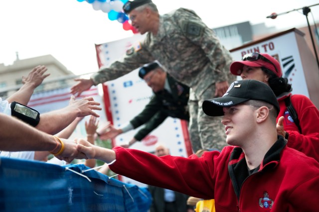 Army Cpl. Vincent M. Bordeaux and Chief of Staff of the Army, Gen. George W. Casey Jr., cheer on the runners of the first annual Run to Home Base 9K run in Boston, Mass., May 23, 2010.  Over 2,000 runners ran and raised 2.4 million dollars to support...