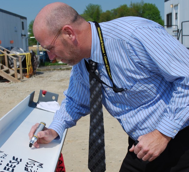 Stakeholders sign final steel beam for new facility