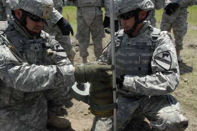 FORT HOOD, Texas - Sgt. Donald Clark (left) and Spc. Adam Boone use tape to attach a fifteen pounds shape charge to a pole, during C Company, 3rd Brigade Special Troops Battalion's , demolition range exercise, on Fort Hood, May 19. A shape charge...