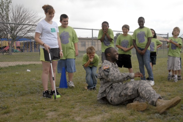 FORT HOOD, Texas - Spc. Michael Baldwin, from Fayetteville, N.C., with B Battery, 2nd Battalion, 82nd Field Artillery Regiment, 3rd Brigade Combat Team, 1st Cavalry Division, shares a hearty laugh with students at Hattie Halstead Elementary School in...