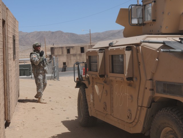 Soldier ground guides a Humvee