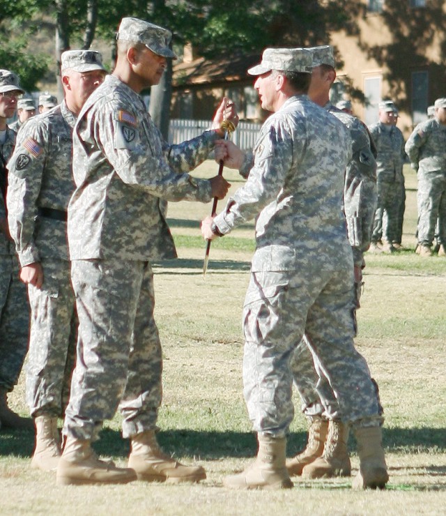 Command Sgt. Maj. Todd Holiday, U.S. Army Intelligence Center of Excellence and Fort Huachuca, and the Military Intelligence Corps command sergeant major, accepts the noncommissioned officers' sword from Maj. Gen. John Custer, commanding general, USA...