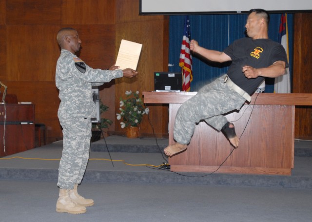 FORT HOOD, Texas-Sgt. James Lee, a unit supply specialist for  the 589th Brigade Support Battalion from Kwang-Ju, Korea, kicks a board held by Command Sgt. Maj. Kelvin Hughes during the Asian/Pacific heritage celebration May 26. The 41st Fires...