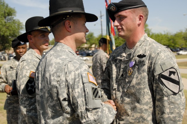 FORT HOOD, Texas-Spc. Michael Cox (right), with Headquarters and Headquarters Company, 3rd Brigade Special Troops Battalion, 3rd Brigade Combat Team, 1st Cavalry Division receives the Purple Heart Medal from Col. Douglas Crissman, commander 3rd BCT, ...